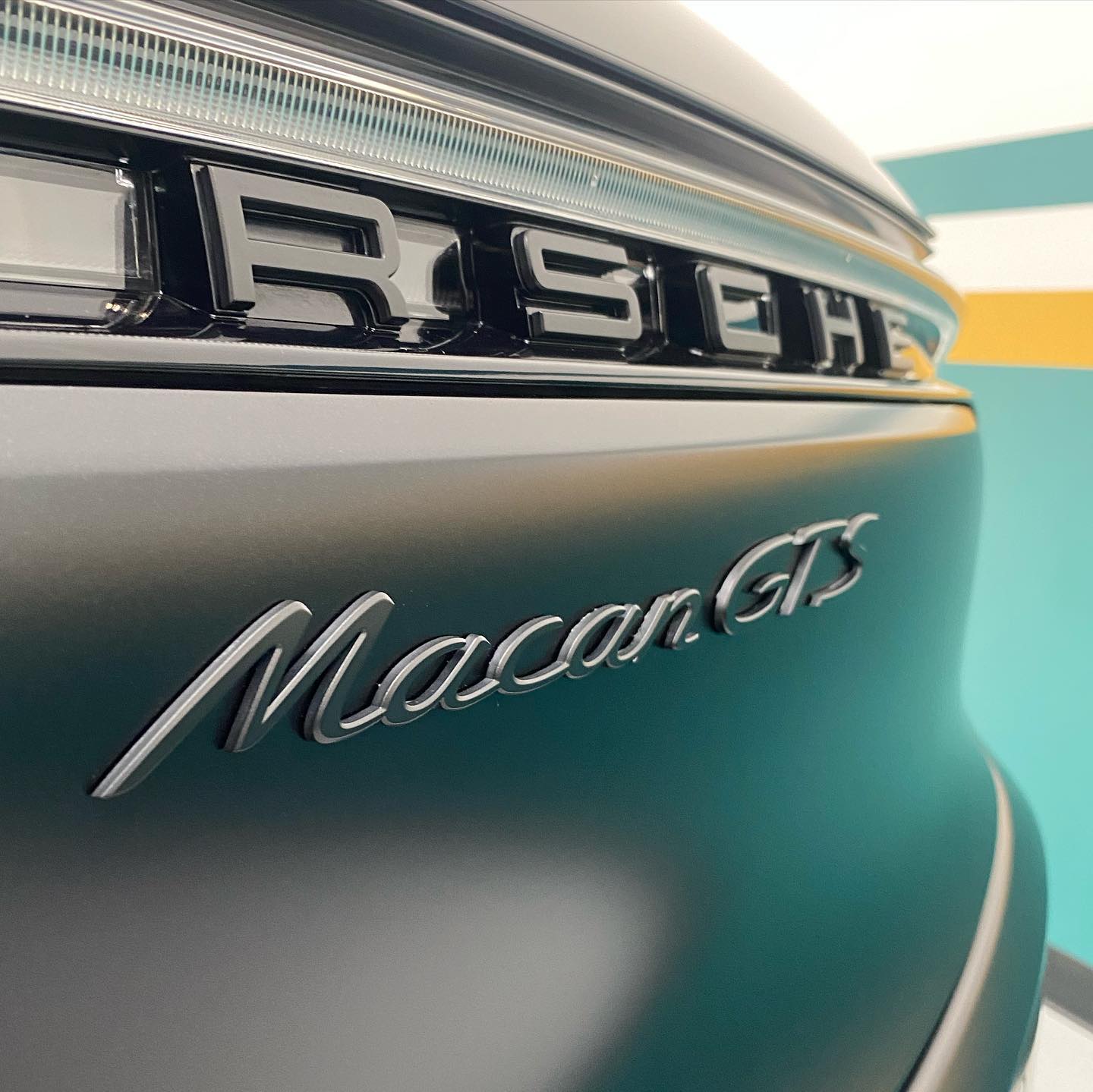 Close-up of a porsche macan gts rear emblem.