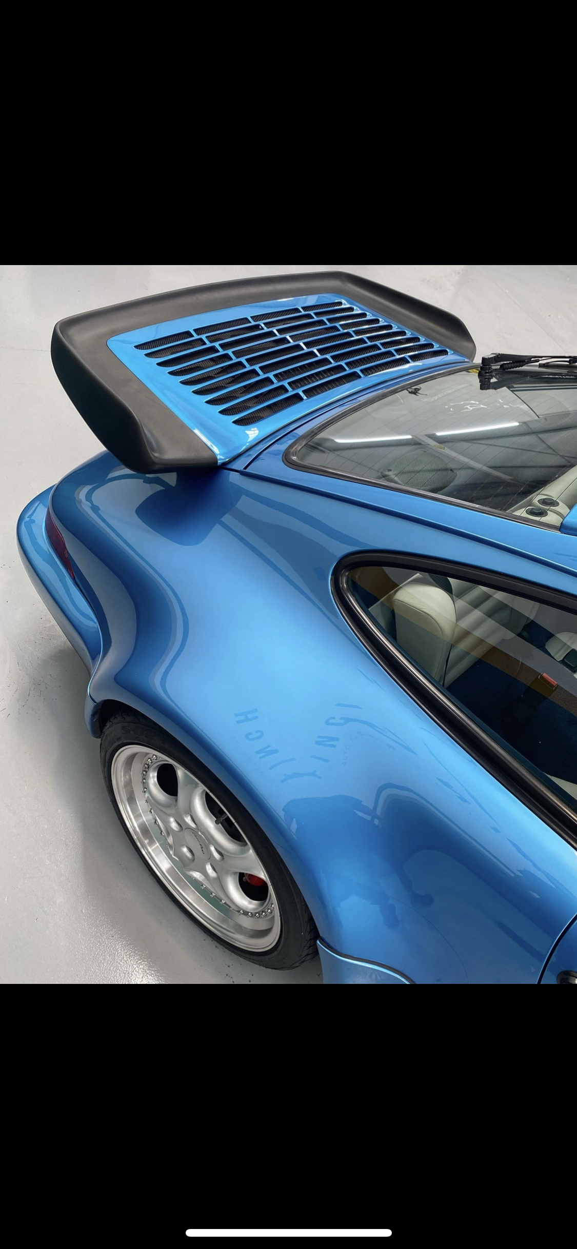 Blue sports car with rear spoiler and solar panel integration.