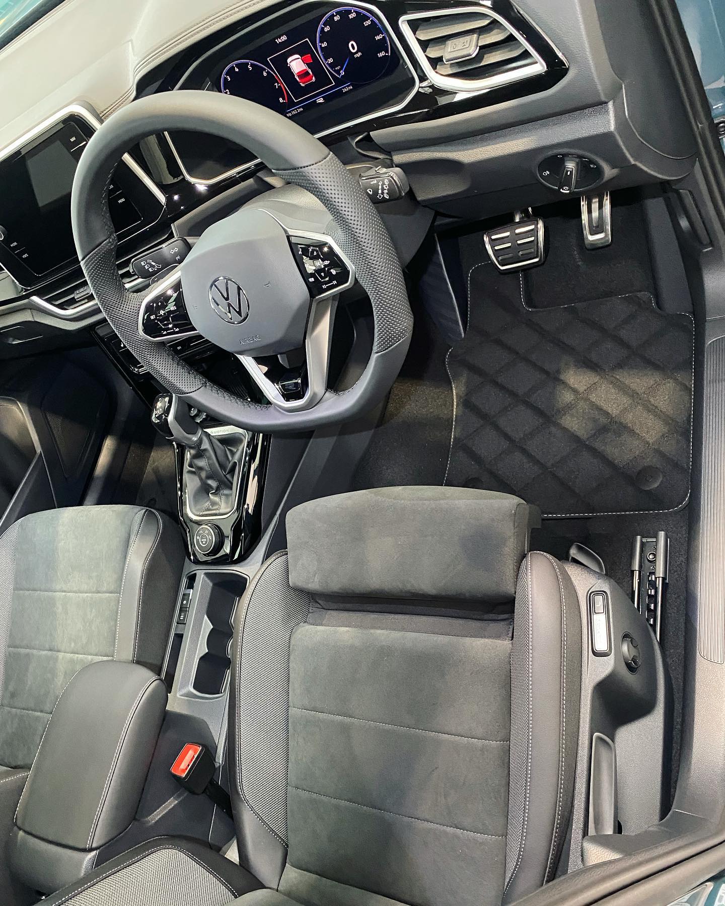 Interior view of a volkswagen vehicle showing the steering wheel, dashboard, and driver's seat.