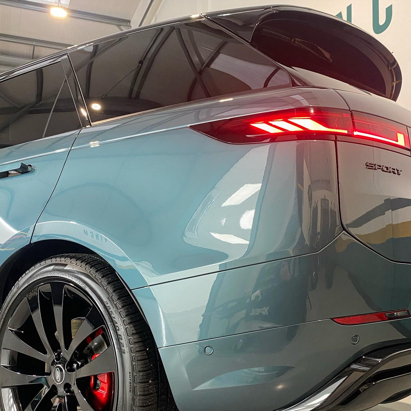 Blue suv with open sunroof and distinctive taillights parked indoors.